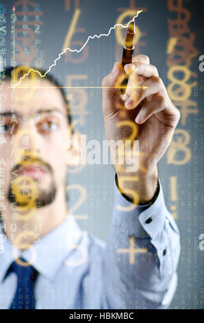 Businessman drawing charts among numbers Stock Photo