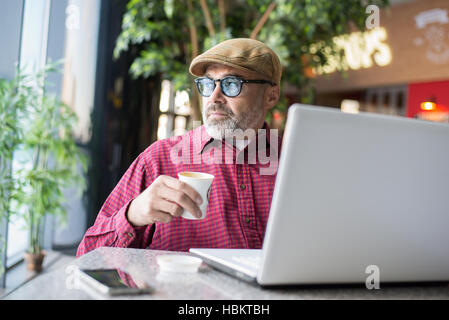 Adult Hipster man using computer in public place Stock Photo