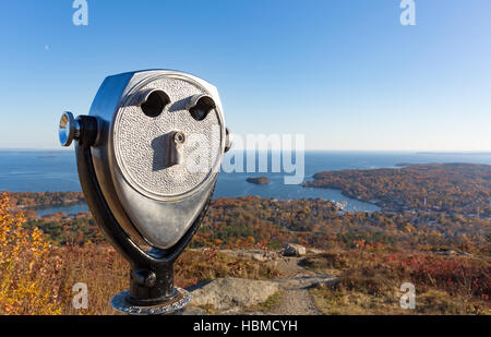 Coin operated binoculars in the foreground with Camden Maine harbor in the distance from Mt. Battie in the late fall. Stock Photo