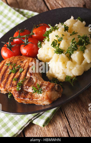 Grilled pork steak with mashed potatoes on a plate close-up. vertical Stock Photo