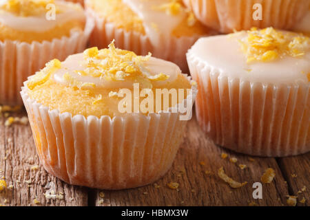 Delicious lemon muffins with icing and zest macro on the table. Horizontal Stock Photo
