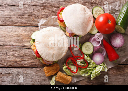 pita with roasted chicken and vegetables close-up on the table. horizontal view from above Stock Photo