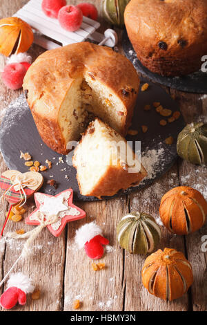 fruit bread panettone and christmas decoration close-up on the table. vertical Stock Photo