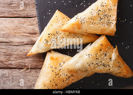 Freshly baked filo pastry with chicken, spinach and cheese close-up on the table. Horizontal view from above Stock Photo