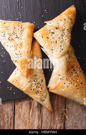 Freshly baked filo pastry with chicken, spinach and cheese close-up on the table. vertical view from above Stock Photo