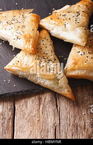 Freshly baked filo pastry with chicken, spinach and cheese close-up on the table. Vertical Stock Photo