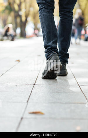 Cropped photo of young walking african man along a street. Stock Photo