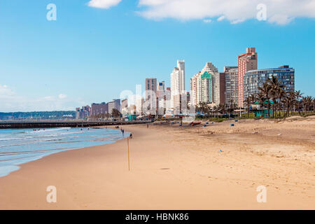 Many unknown people enjoy early morning visit to beach  under blue cloudy sky at Golden Mile beach front Stock Photo