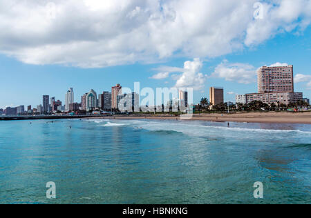 Many unknown people enjoy early morning visit to beach  under blue cloudy sky at Golden Mile beach front Stock Photo