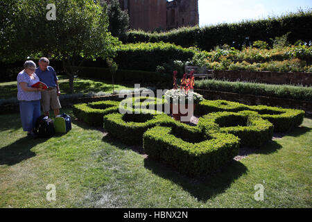 English senior citizens, 70s, husband and wife visit the Elizabethan garden in front of Leicester's Gatehouse, Kenilworth Castle Stock Photo