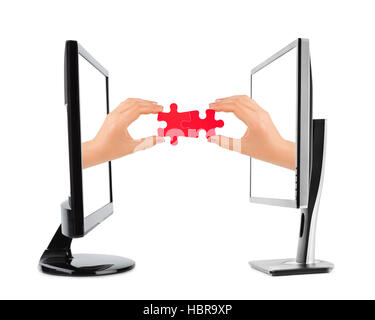 Hands and puzzle in computers Stock Photo