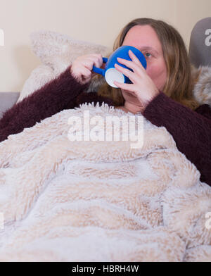 Woman is sick and drinks tea