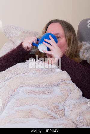 Woman is sick and drinks tea