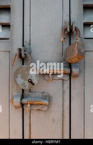 rusty old padlocks and locking bolts on metal doors Stock Photo