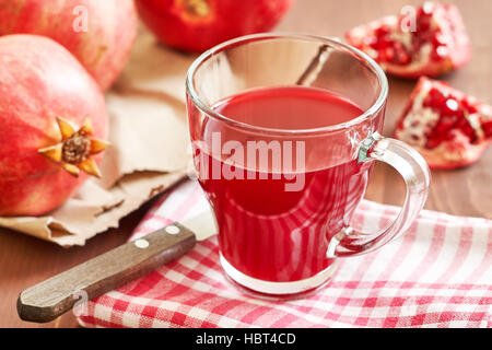 Glass of pomegranate juice with fresh fruits on wooden table Stock Photo