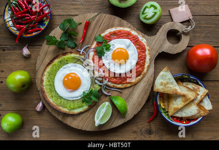 huevos divorciados, fried eggs on corn tortillas with salsa verde and  roja, mexican breakfast Stock Photo