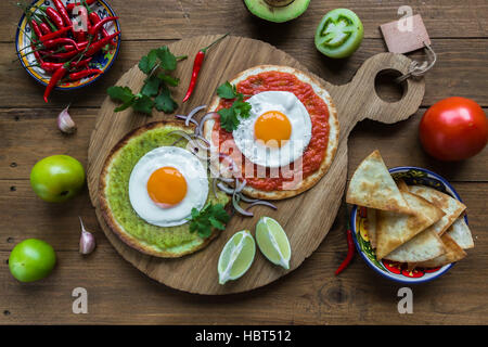 huevos divorciados, fried eggs on corn tortillas with salsa verde and  roja, mexican breakfast Stock Photo
