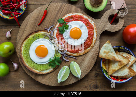 huevos divorciados, fried eggs on corn tortillas with salsa verde and  roja, mexican breakfast Stock Photo