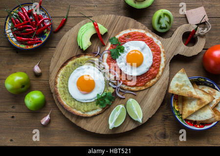 huevos divorciados, fried eggs on corn tortillas with salsa verde and  roja, mexican breakfast Stock Photo
