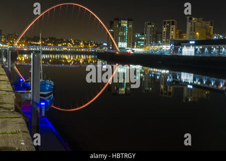 Night-time photograph of Newcastle and Gateshead Quayside in England with Boat, Millennlum Bridge and other Landmarks in view Stock Photo