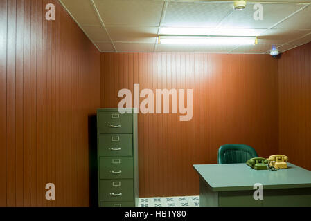 Old desk and chair in small office with vintage rotary phones, Saigon Stock Photo