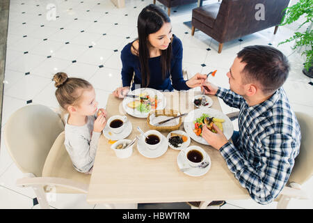 Family sitting together at table in a restaurant Stock Photo