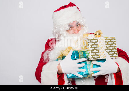 Santa holding many Christmas gifts Stock Photo