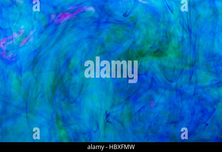 Abstract underwater color background. Color drop underwater creating a silk drapery. Ink swirling underwater. Blue and green Stock Photo