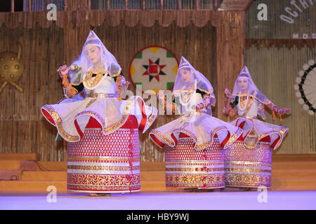 A dance group of Manipur dancers performing Manipur Rass dance on stage . Ajmer, Rajasthan, India during a tribal dance festival Stock Photo