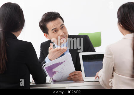 Portrait of smiling middle aged businessman having a meeting with his coworkers Stock Photo