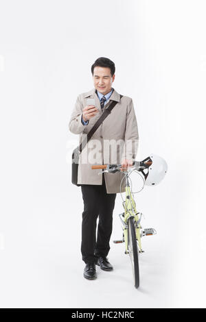 Smiling middle aged man using cellphone holding bicycle Stock Photo
