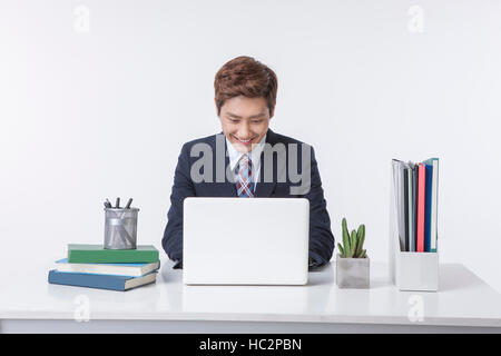 Young smiling businessman using notebook computer looking down at work Stock Photo