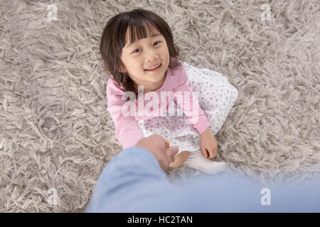 High angle view of smiling six-year-old Korean girl holding her father's hand Stock Photo