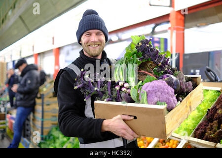 Trader Ben Perry from French Garden, prepares a box of purple seasonal vegetables ahead of Christmas at New Covent Garden Market, in Nine Elms, London. Stock Photo