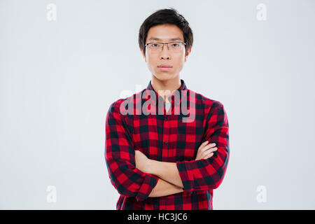 Portrait of handsome young man in casual shirt keeping arms crossed and isolated over white background Stock Photo