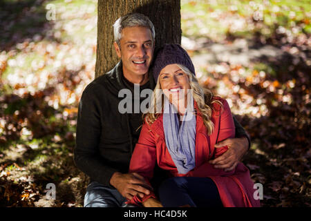 Portrait of couple sitting under tree Stock Photo