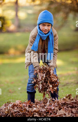 portrait of cute boy in leaves of the tree Stock Photo - Alamy
