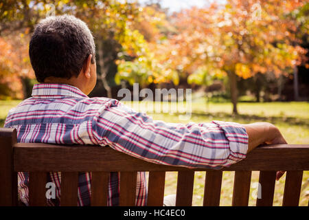 Thoughtful elderly man sitting alone on a bench Stock Photo