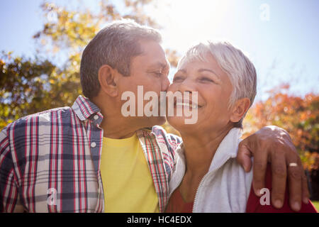 An elderly man kissing his wife Stock Photo