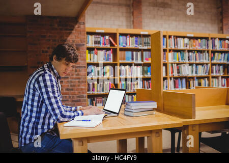 Student using laptop in library Stock Photo