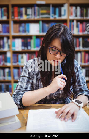 Female student looking at notes in library Stock Photo