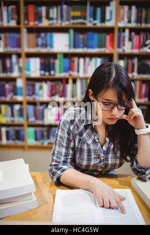 Female student reading book in library Stock Photo