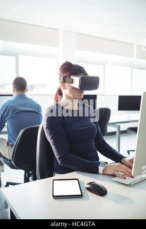Mature student in virtual reality headset using computer Stock Photo