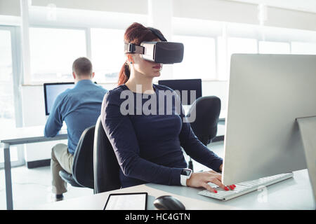 Mature student in virtual reality headset using computer Stock Photo