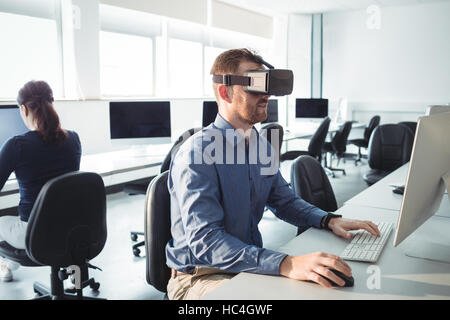 Mature student in virtual reality headset using computer Stock Photo