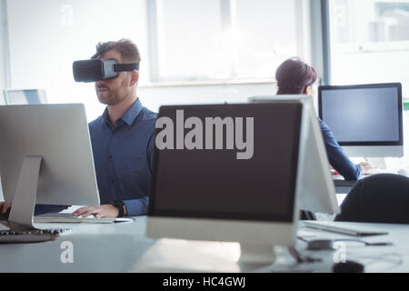 Mature student in virtual reality headset using computer Stock Photo