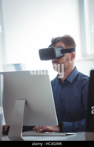 Mature student in virtual reality headset using computer Stock Photo
