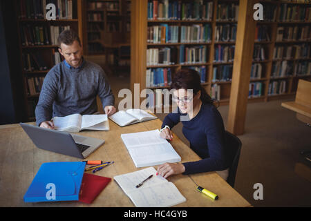 Mature students working together in college library Stock Photo