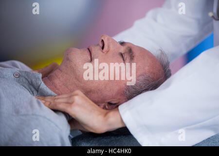 Senior man receiving shoulder massage from physiotherapist Stock Photo