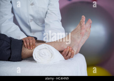 Senior man receiving foot massage from physiotherapist Stock Photo